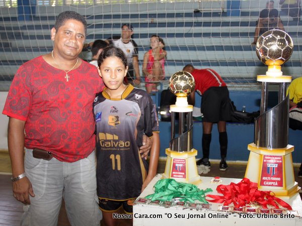 Papai Mauricio, vededor da Construluz, feliz da vida com a filha Maira que foi campe&atilde; posa ao lado dos trof&eacute;us 