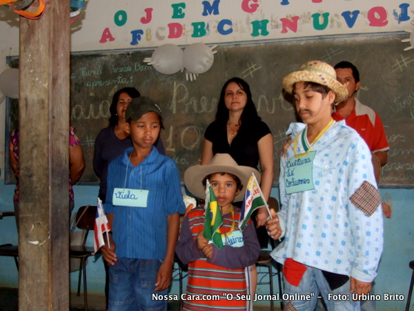 Alunos da escola seguram miniaturas de bandeiras repersentando as bandeiras do Barsil da Bahia e do munic&iacute;pio de Eun&aacute;polis 