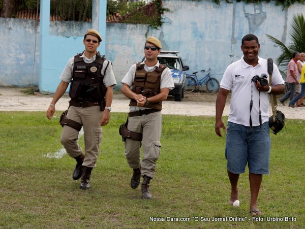 O organizador da competi&ccedil;&atilde;o Luciano Santos entra no gramado ladeado por dois policiais militares que vieram fazer a seguran&ccedil;a do jogo 