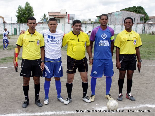 O trio de arbitragem com os capit&atilde;es das duas equipes