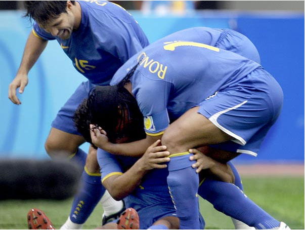 Encoberto, Anderson recebe o abraço de Ronaldinho, enquanto Diego se aproxima AP / Agência