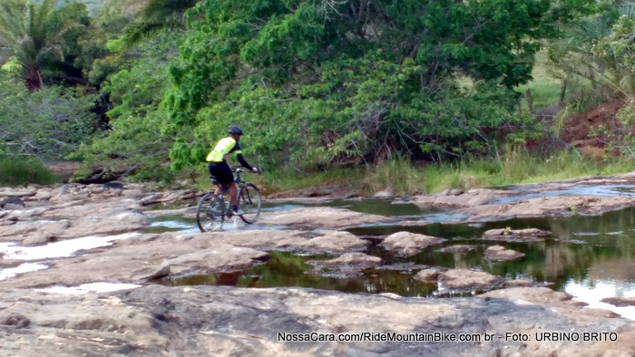 O ciclista passa pedalando pelo leito do rio
